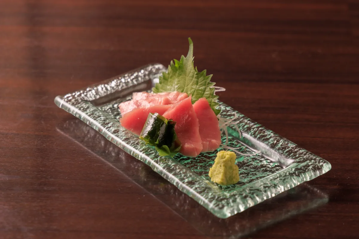 緑の角皿に盛り付けたまぐろの刺身